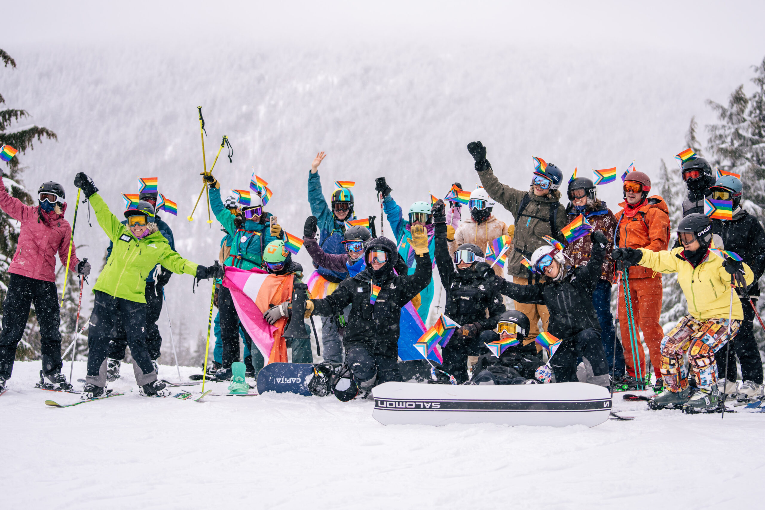 LGBTQ+ skiiers and snowboarders celebrating outside on a snowy mountian